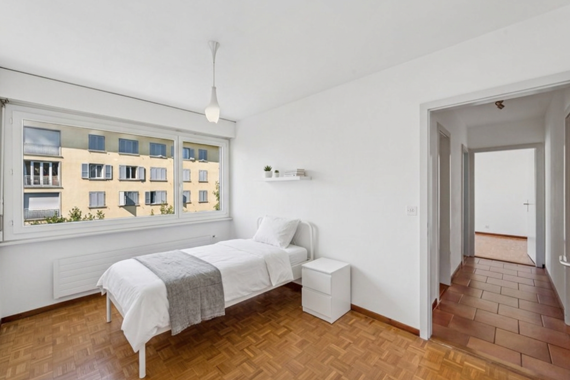 Second bright bedroom with parquet flooring