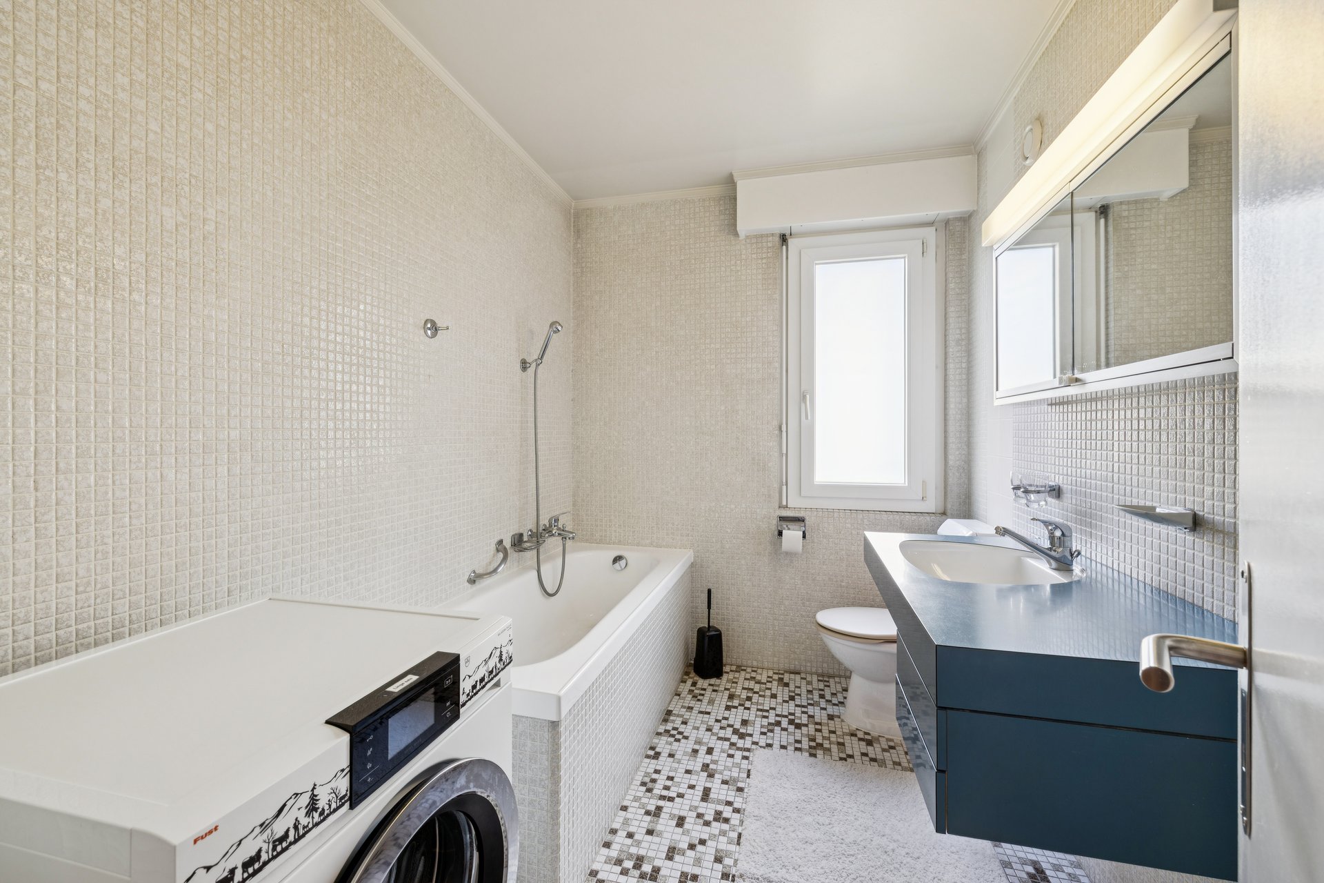 Bathroom with bathtub and washing column